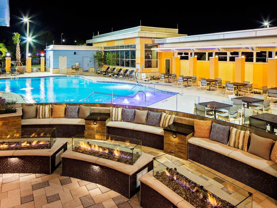 A poolside area with lounge chairs, a fire feature, and outdoor seating.