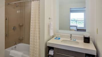 A bathroom with a bathtub, shower, and sink.