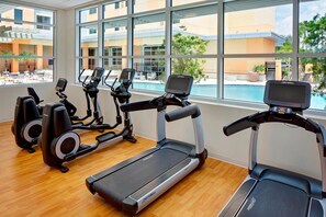 A gym with treadmills, ellipticals, and a pool view. - Hyatt House across from Universal Orlando Resort (Orlando)