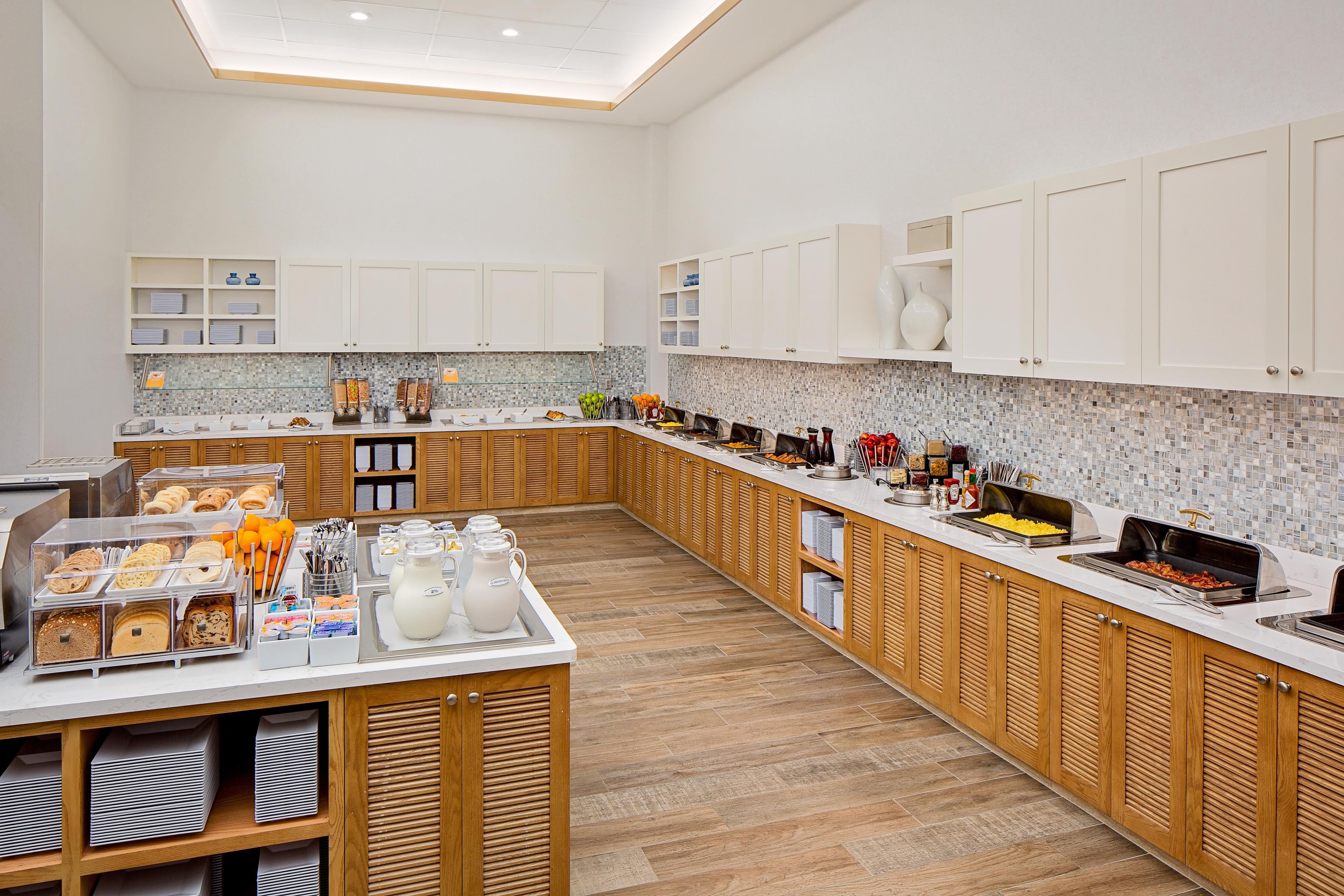 A spacious kitchen with a long counter, various food stations, and storage cabinets.