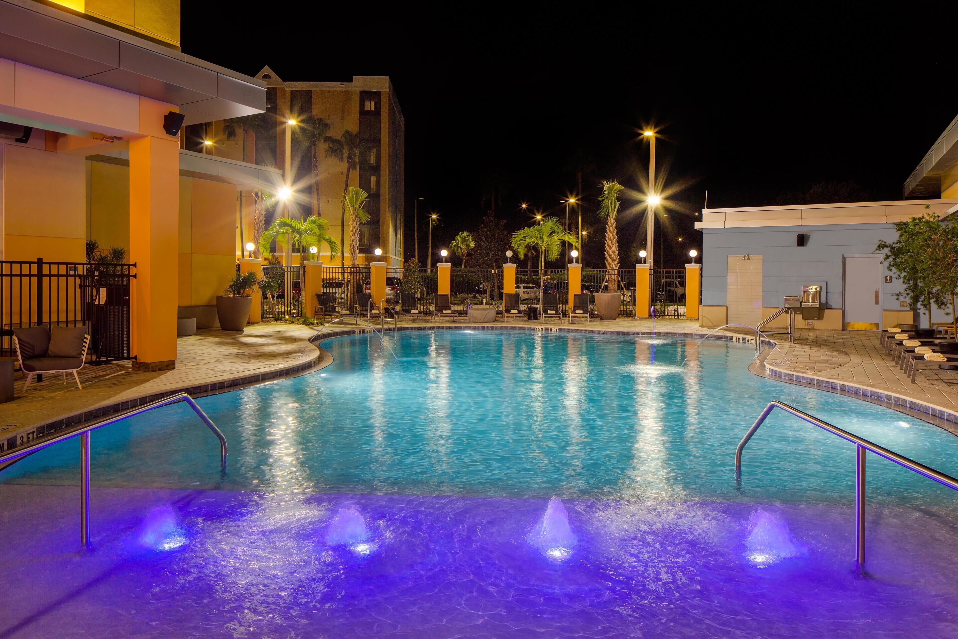 Una piscina al aire libre, sillones reclinables de piscina