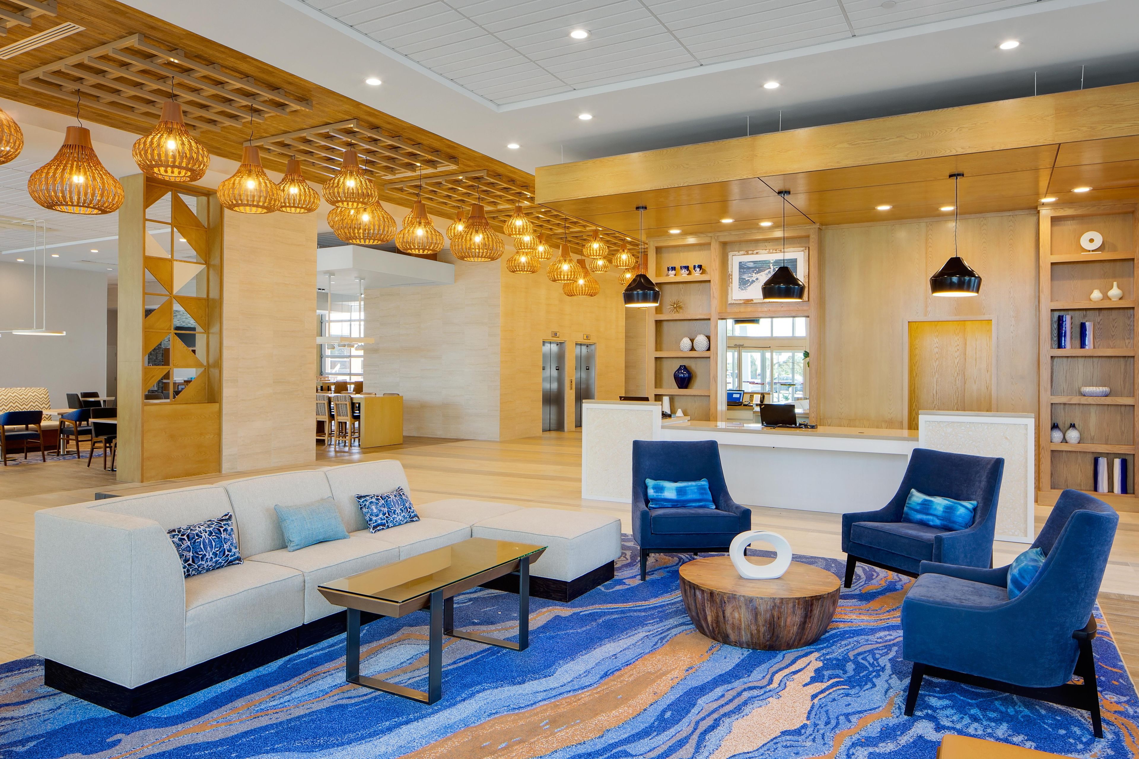 Eine moderne Lobby mit Empfangsschalter, Sitzgelegenheiten und einer Treppe.