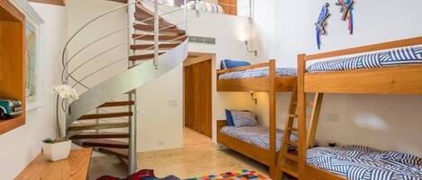 A multi-level room with bunk beds, a spiral staircase, and a colorful checkered floor.