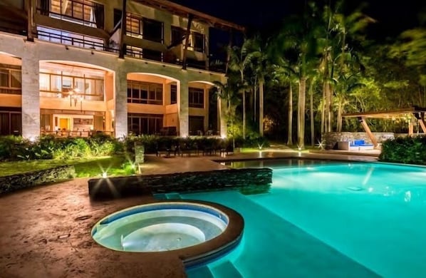 Un hôtel doté d’une piscine, d’un espace extérieur aménagé et de palmiers.