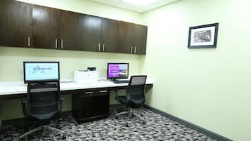 A workspace with two desks, computers, and office chairs.