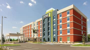 Home 2 hotel features a striking exterior with large windows and a covered parking area.