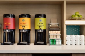 Three coffee makers labeled HOT H2O, GOURMET, and DECAF on a counter.