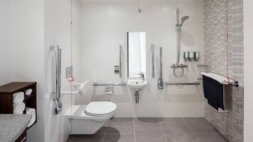A modern bathroom with a toilet, sink, and shower.
