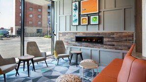 A modern lobby with a fireplace, seating area, and artwork on the wall.