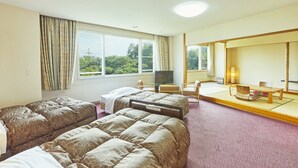 Una habitación de hotel con dos camas, televisión, escritorio y una silla.