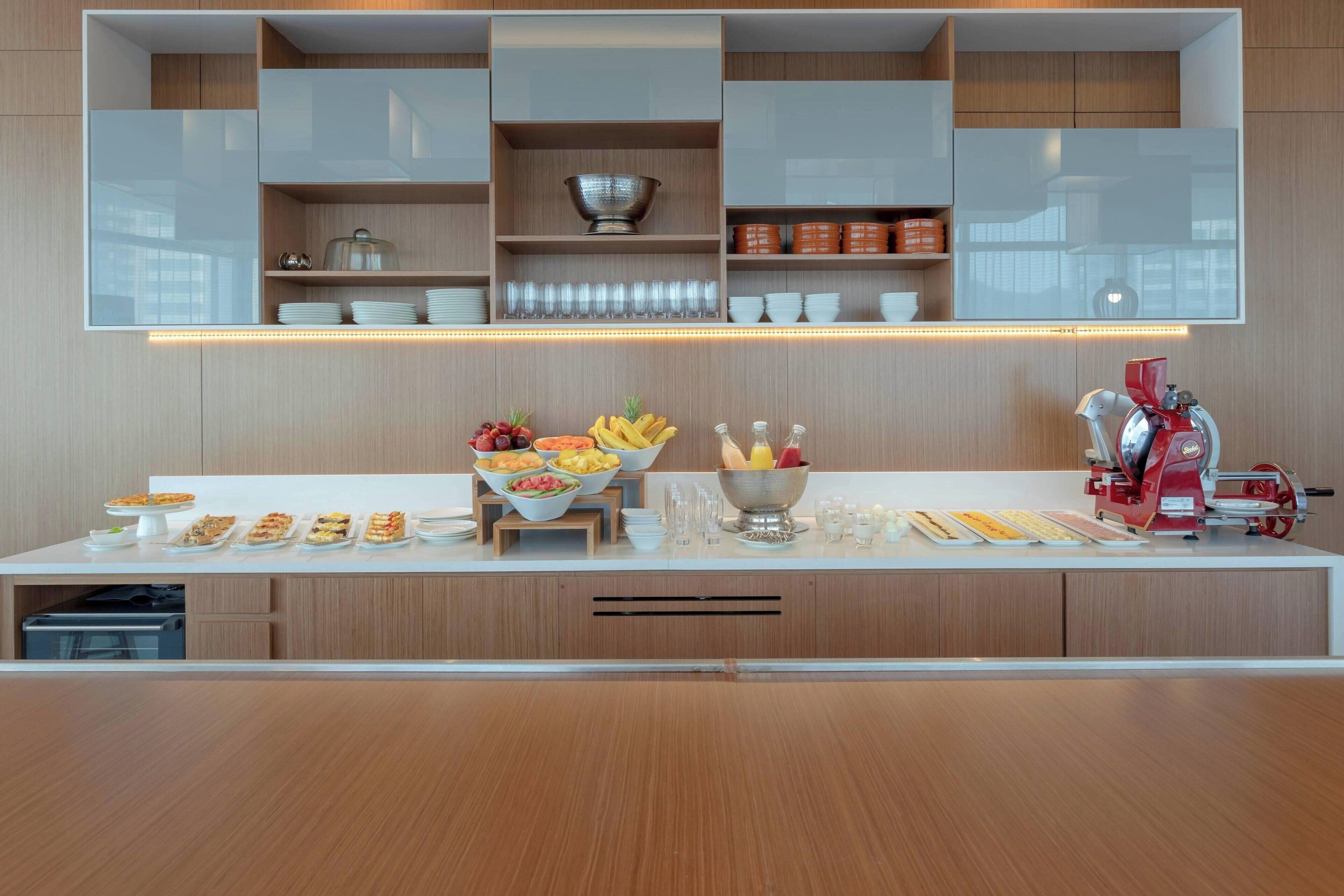 A modern kitchen with built-in shelves, a coffee machine, and a fruit bowl.
