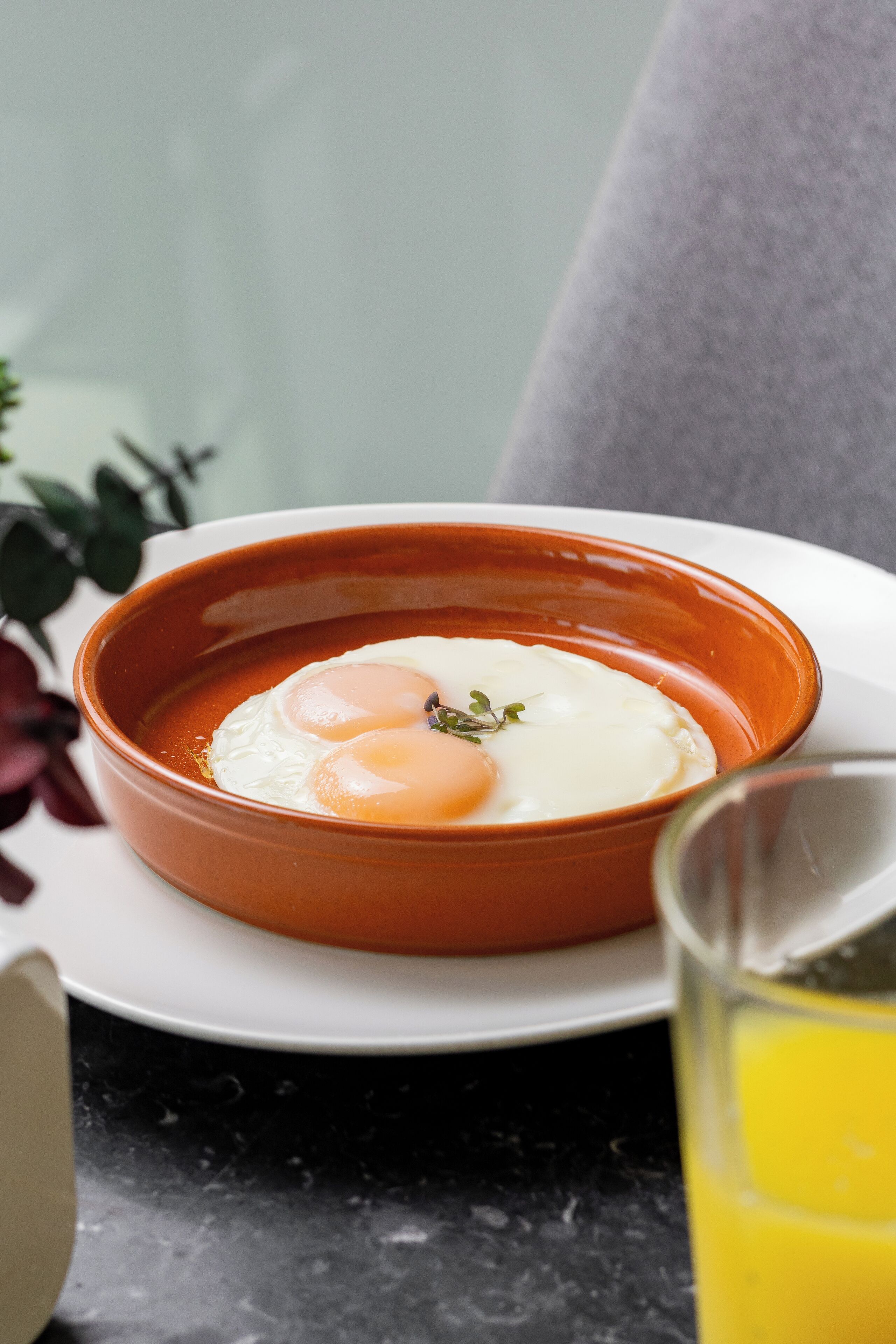 Un bol de soupe avec des œufs, servi dans une assiette blanche.