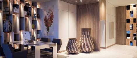 Een modern interieur met een eethoek, boekenkasten en decoratieve vazen.
