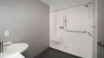 Ein modernes Badezimmer mit Dusche, Waschbecken und Handtuchhalter.