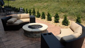 An outdoor patio with a curved sofa, a round fire pit, and a small table. - Fairfield Inn & Suites by Marriott Somerset (Somerset)