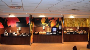 A hotel reception area with a wooden counter, a digital screen, and a fruit-themed mural. - Fairfield Inn & Suites by Marriott Somerset (Somerset)
