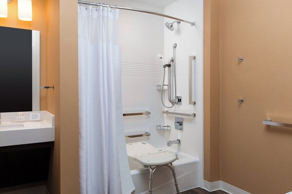 A modern bathroom with a shower, a toilet with a safety seat, a vanity with a mirror, and a towel rack. - TownePlace Suites by Marriott Austin North/Lakeline (Austin)