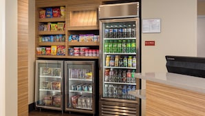 Una estación de autoservicio para bebidas con opciones refrigeradas y no refrigeradas, que incluye aperitivos y bebidas.