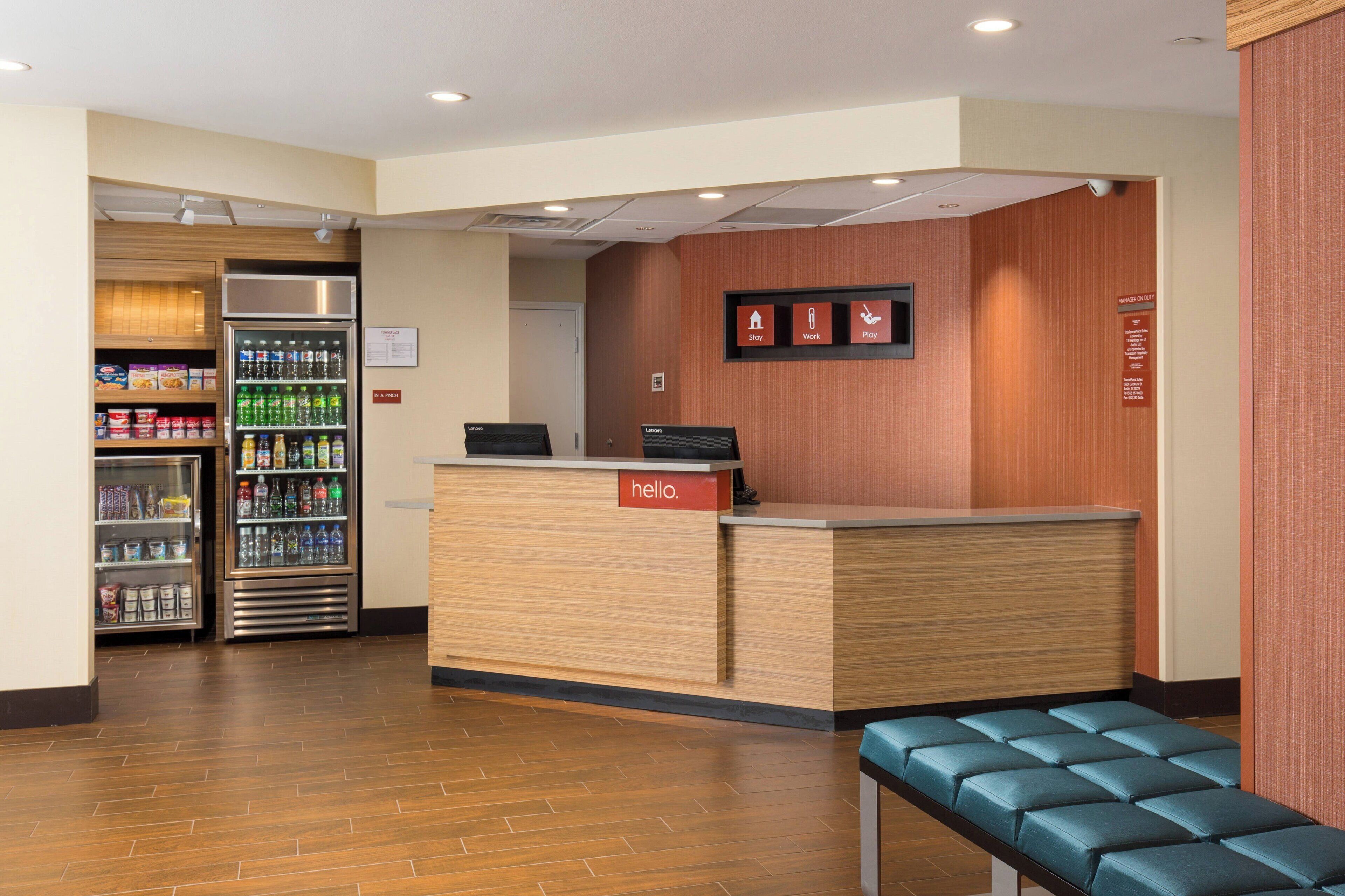 A reception area with a wooden reception desk, a seating area, and vending machines.