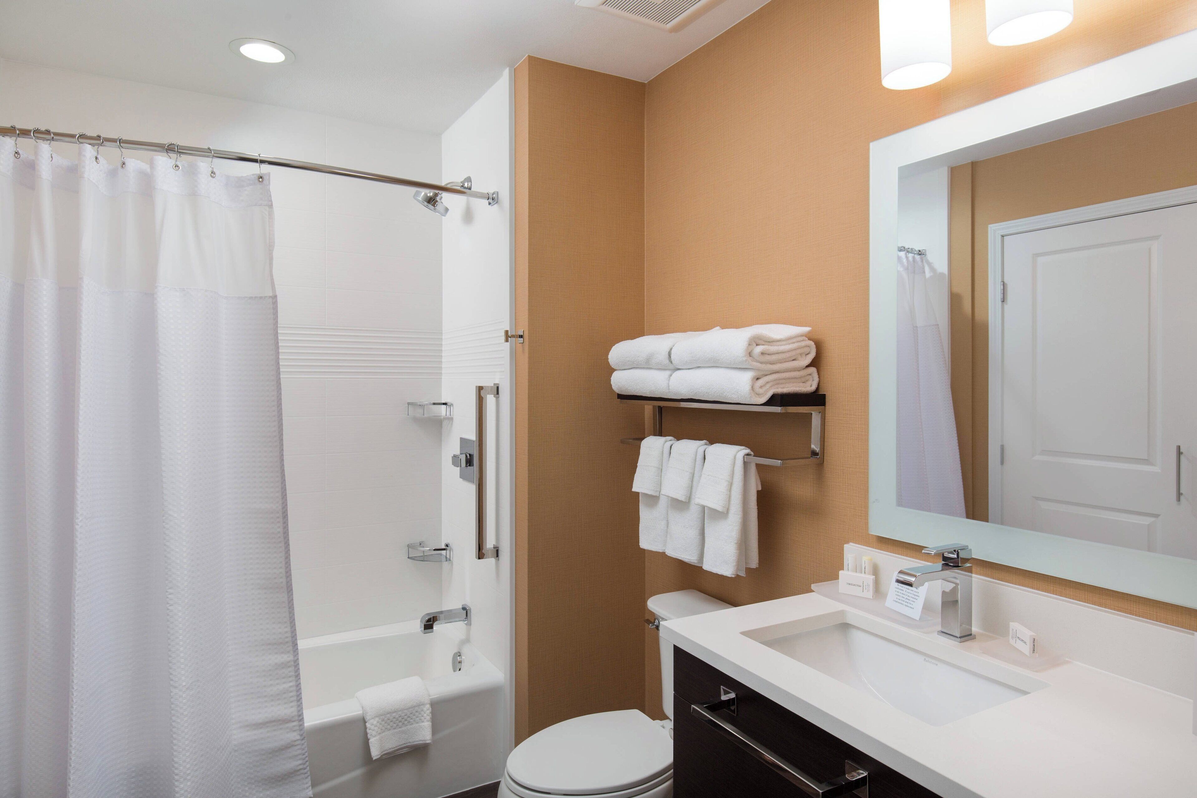 A modern bathroom with a bathtub, toilet, and sink.