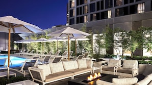 A rooftop pool area with lounge chairs, a sofa, and umbrellas. - AC Hotel by Marriott Dallas by the Galleria (Dallas)