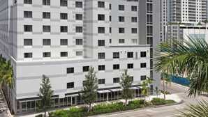 Een hotel met meerdere verdiepingen, modern vormgegeven, met een gelijkmatige gevel en diverse balkons.