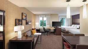 A hotel room with a bed, desk, chair, and a TV. - Residence Inn by Marriott Greenville (Greenville)