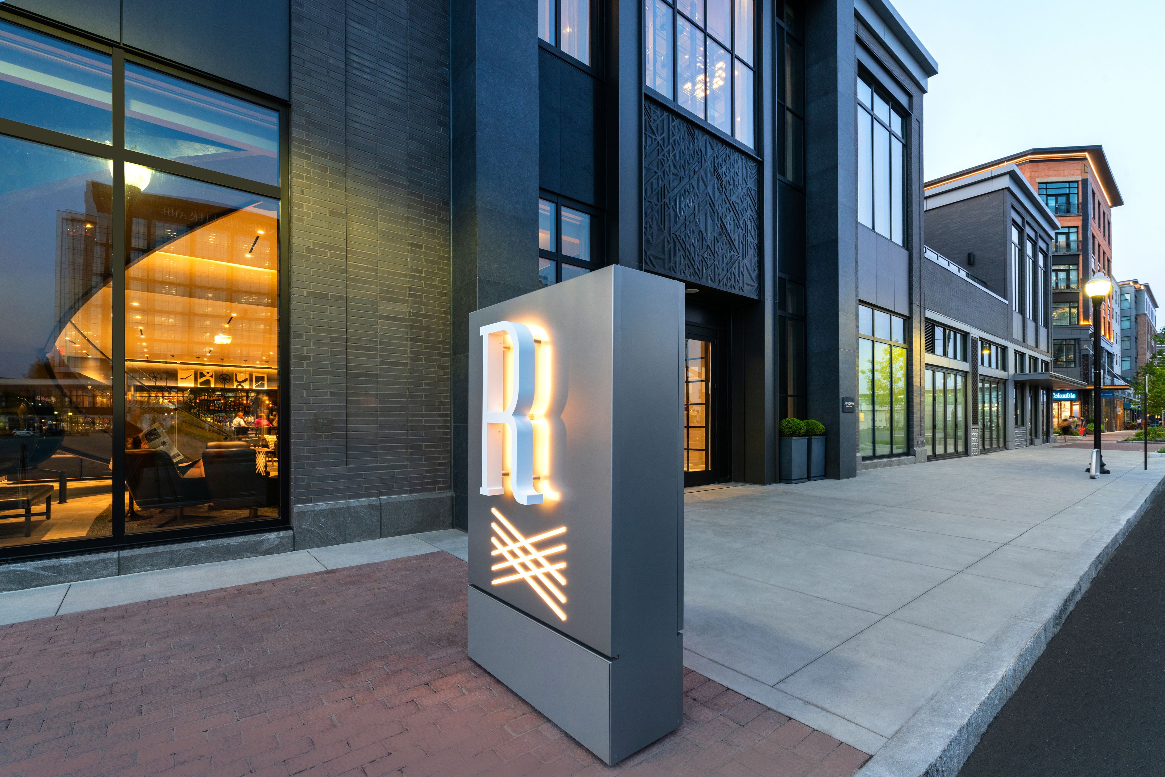 A modern building with large windows and a prominent illuminated sign.