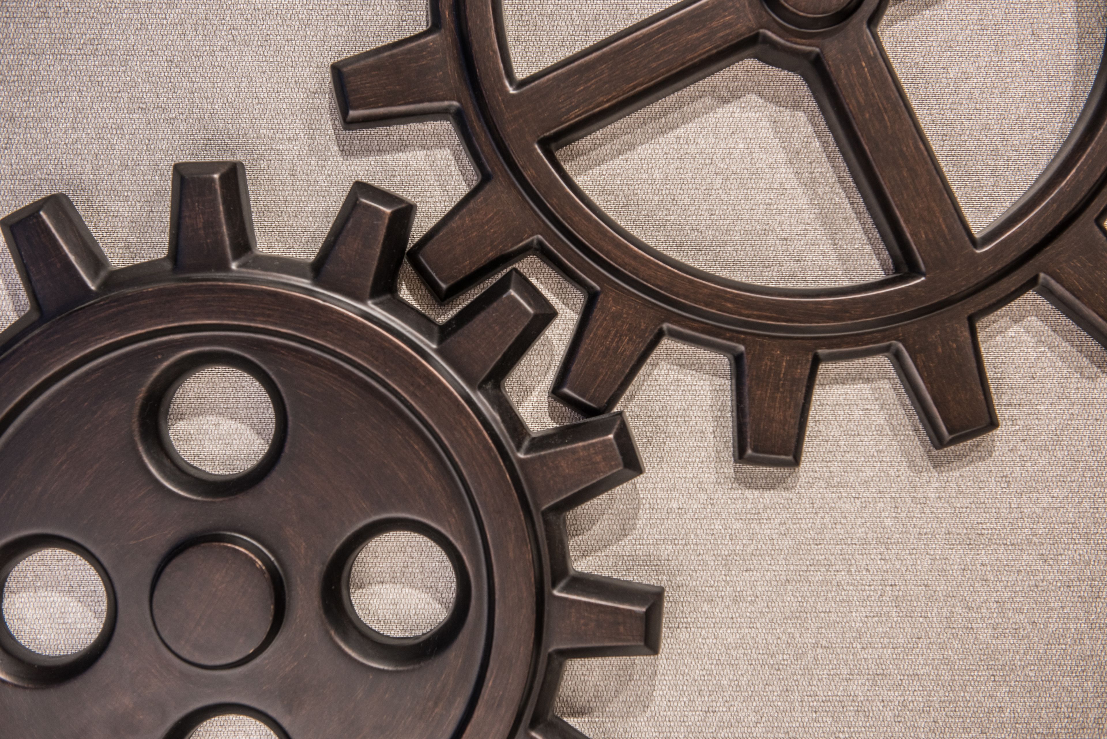 Two interlocking gears with a textured background.
