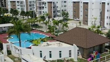 Una piscina al aire libre, sillones reclinables de piscina