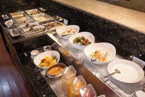 A buffet setup with various food items and beverages.