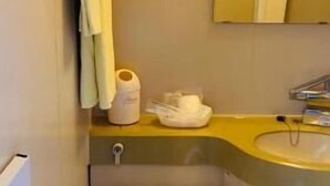 Un baño pequeño con inodoro, lavabo y un perchero para toallas.