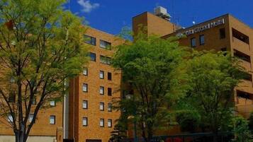 A multi-story hotel building with a brick facade and a sign indicating it is a hotel.