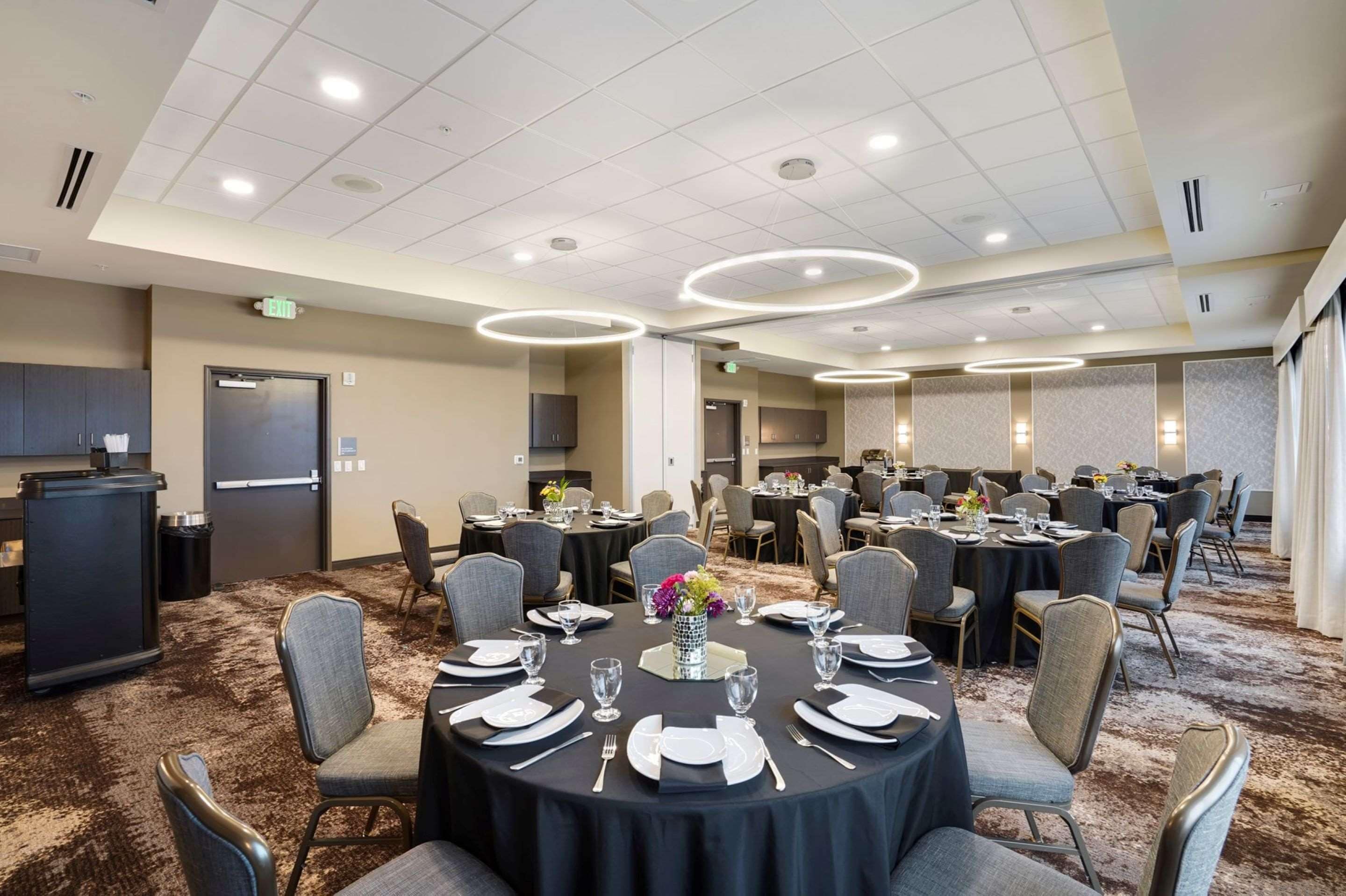A conference room with round tables, chairs, and a podium.