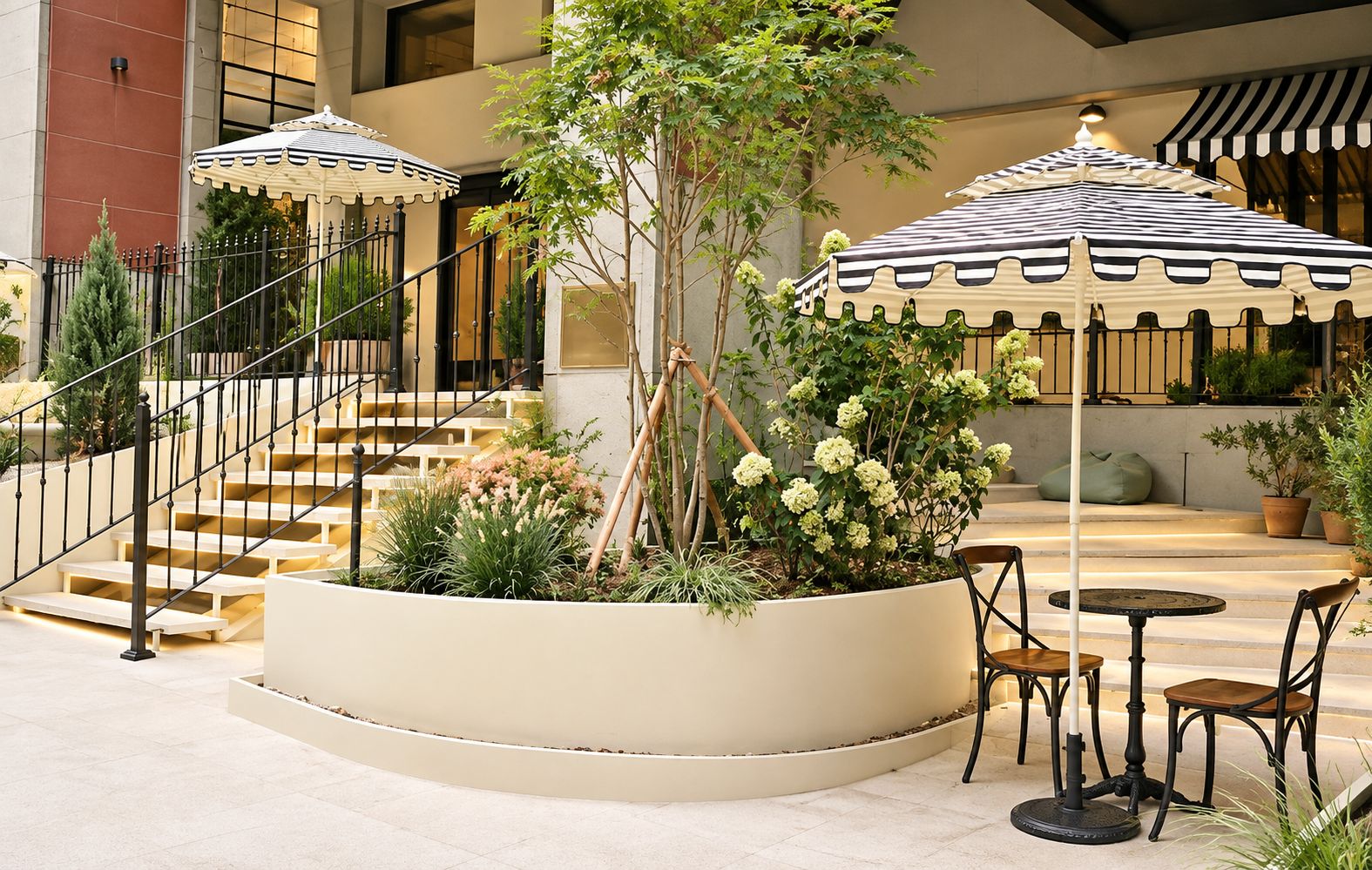 A courtyard with a central planter, outdoor seating, and a staircase.
