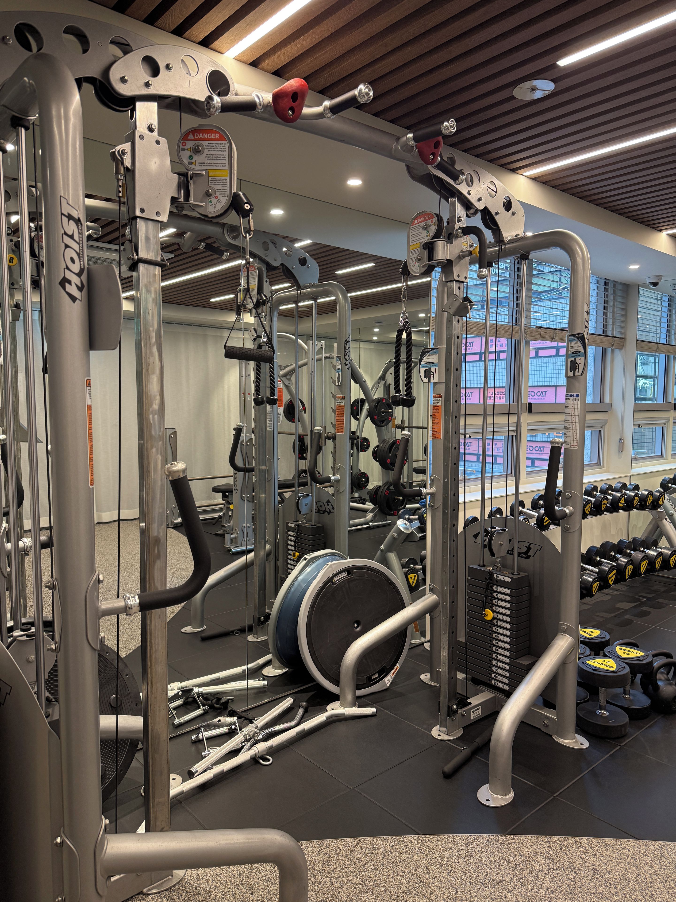 Un gimnasio con diversos equipos de ejercicio, incluyendo máquinas de pesas y mancuernas.