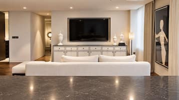 Una sala de estar moderna con un televisor de pantalla plana grande, un sofá blanco y un suelo de mármol.