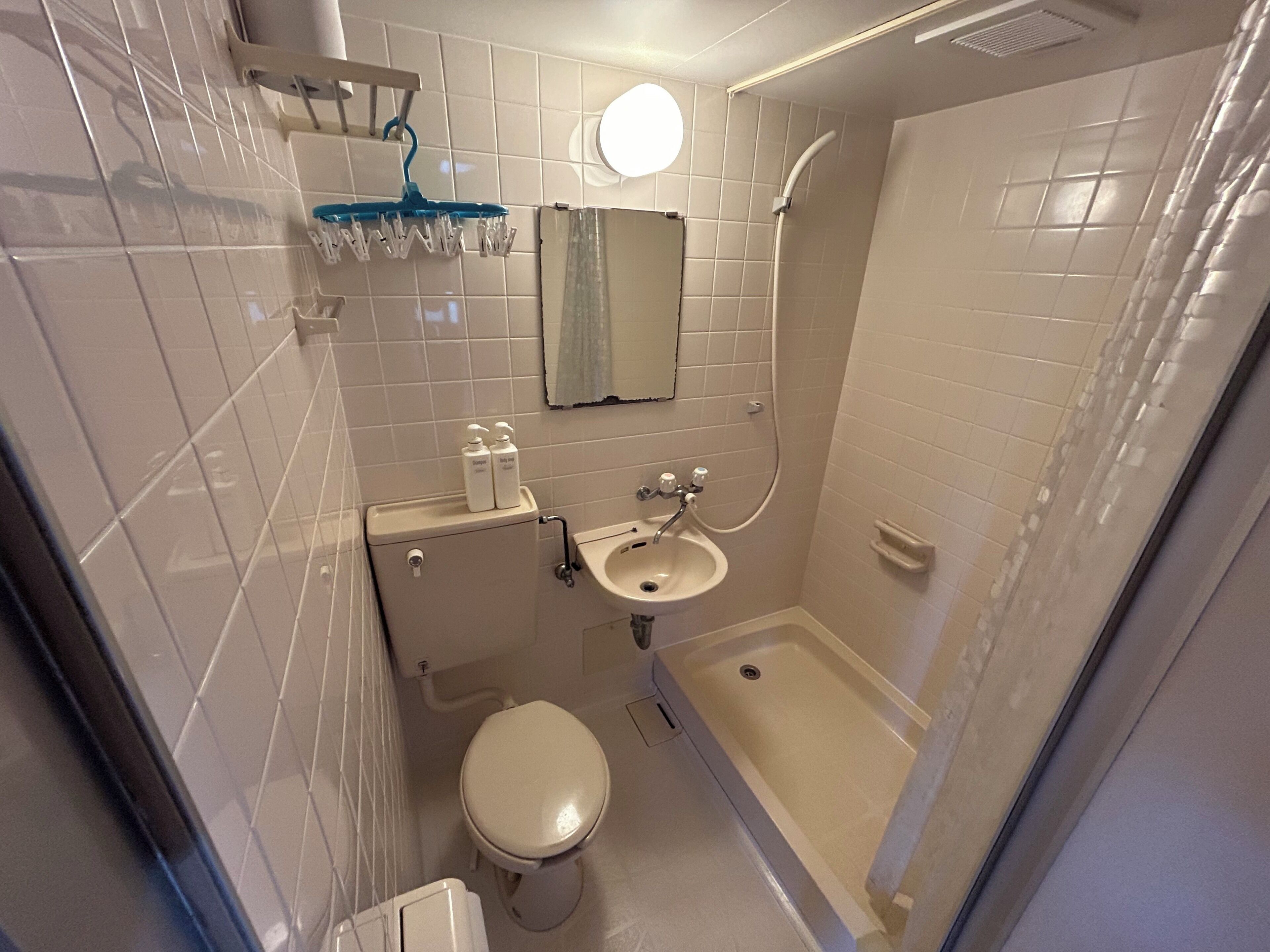 A bathroom with a toilet, sink, and shower.