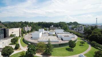 Un bâtiment moderne doté d’une cour centrale circulaire, entourée de structures à toits plats, qui font probablement partie d’un hôtel ou d’un complexe institutionnel.