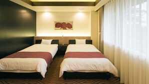 Ein Hotelzimmer mit zwei Betten, einem Gemälde an der Wand und einem großen Fenster mit Vorhängen.