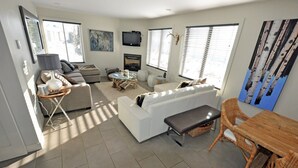 Ein modernes Wohnzimmer mit einer Couch, einem Esstisch und einem Kamin.