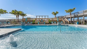 A clear blue pool with a wooden deck, palm trees, and a covered seating area. - 11th Floor, Beachfront, BEST BEACH, Amazing Views, Beachside 1, Sandestin! (Miramar Beach)