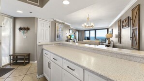 A spacious kitchen with a large island, white cabinetry, and a view to the living area. - 11th Floor, Beachfront, BEST BEACH, Amazing Views, Beachside 1, Sandestin! (Miramar Beach)