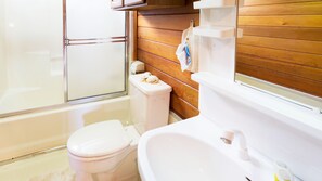 Deluxe villa | Badkamer | Een bad/douchecombinatie, een diep bad, gratis toiletartikelen