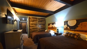 A bedroom with two beds, a wooden ceiling, and a mountain-themed headboard. - Great Location=Great Vacation. Dog Friendly Condo w/ Awesome Ski Access (Mt. Crested Butte)