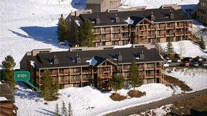 A multi-story hotel with a modern architectural design, featuring balconies and large windows. - Great Location=Great Vacation. Dog Friendly Condo w/ Awesome Ski Access (Mt. Crested Butte)
