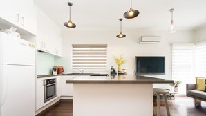 A modern kitchen with a central island, white cabinetry, and pendant lighting. - RYE Classic- 4bed, perfect location-up to 13 guests, foxtel- BONUS* NIGHTS OFFER (Rye)