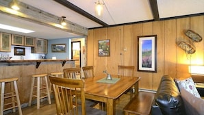 A cozy dining area with wooden furniture, a bar, and framed pictures on the walls. - Close to Everything! Ski-In/Out Condo. Doggie Friendly, Mtn Views, Fireplace (Mt. Crested Butte)