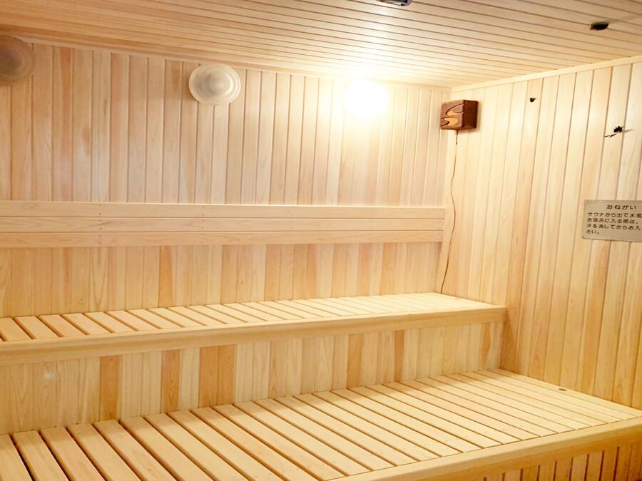 Una sauna con bancos de madera y techo con ventilación.
