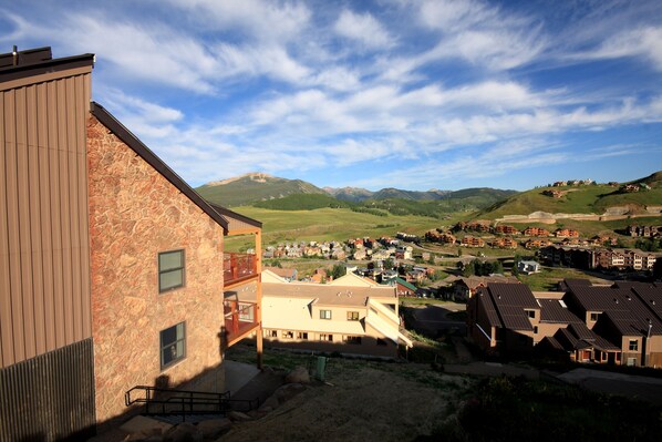 A residential area with a mix of modern and traditional architecture, featuring a prominent building with a stone facade and a wooden structure to the left.
